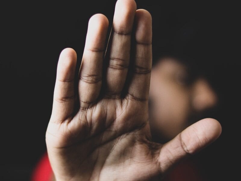 persons left hand on black background