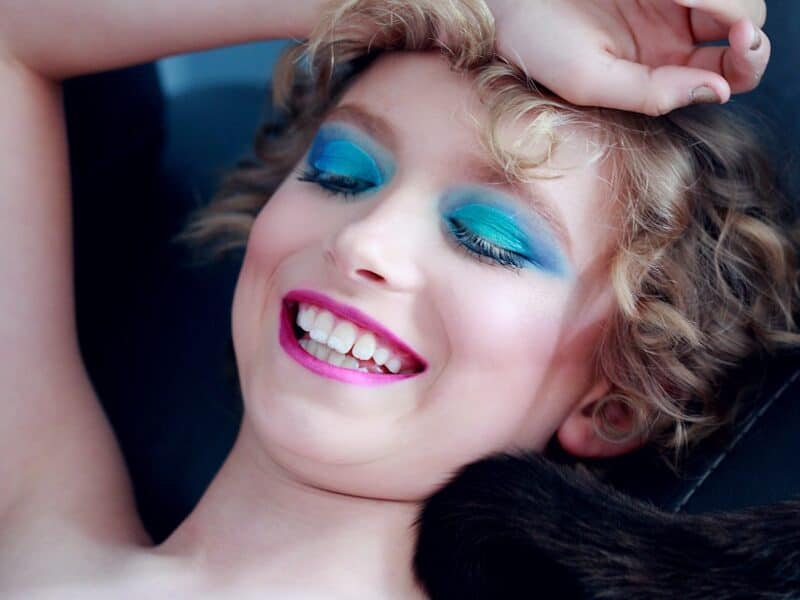 smiling woman lying and putting right hand on her head