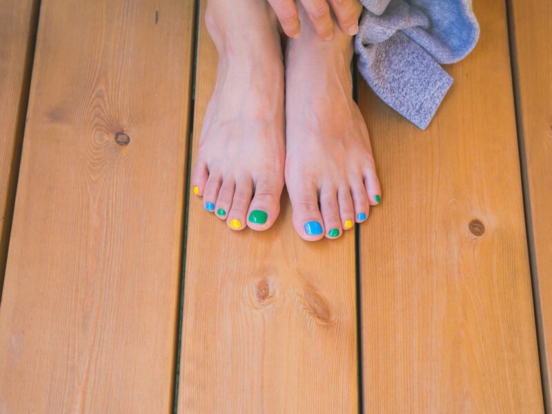 person with orange nail polish