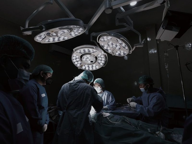 A group of doctors standing around a hospital bed
