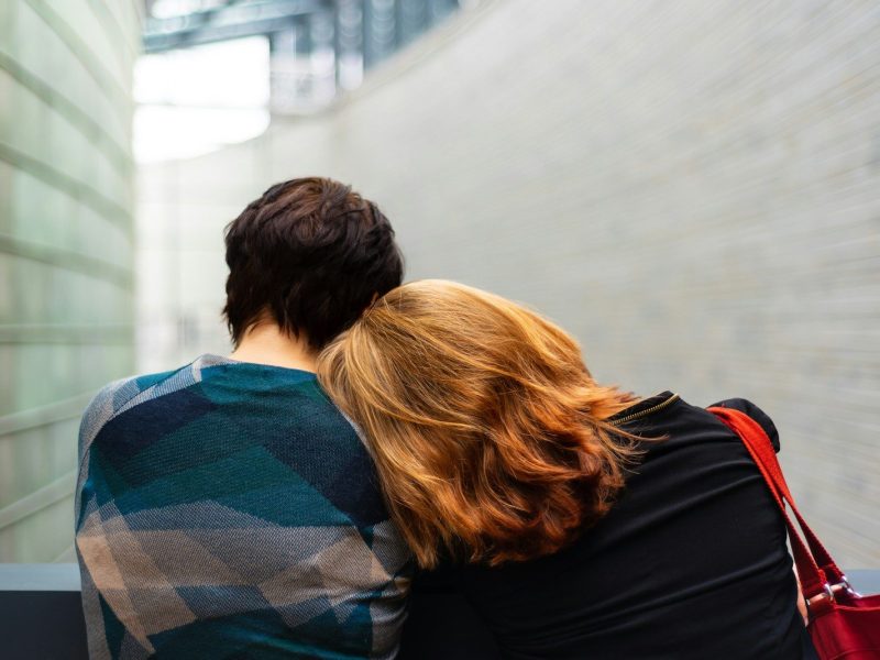 a woman rests her head on another person's shoulder